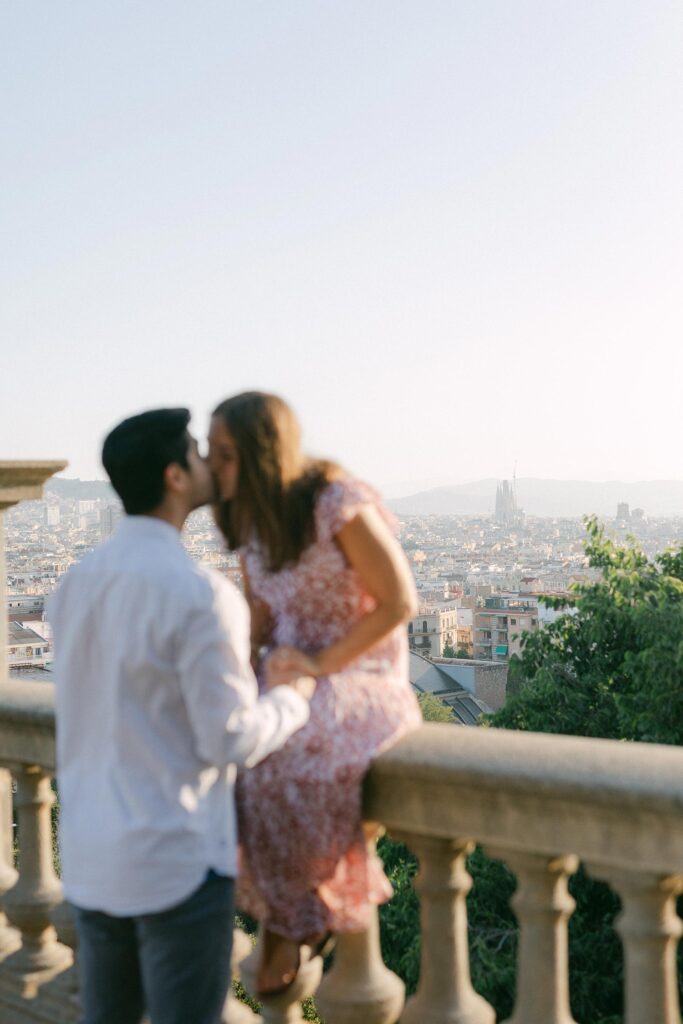 Young couple kissing after the surprise marriage proposal on the top of MNAC museum in Barcelona