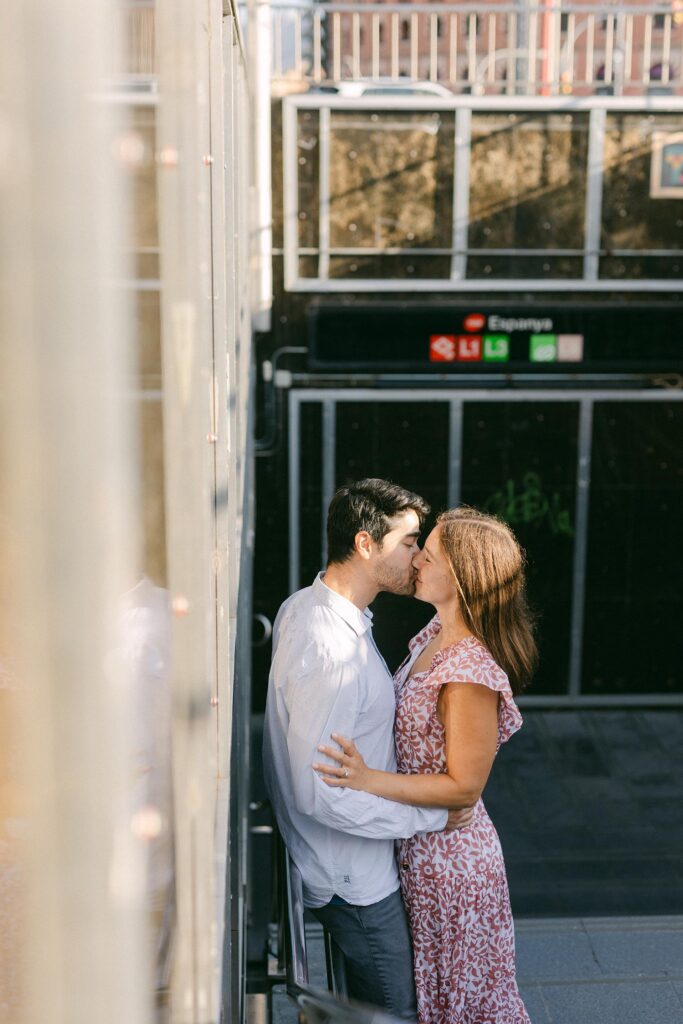 Young couple kissing at the metro of Barcelona after the surprise marriage proposal on the top of MNAC museum in Barcelona