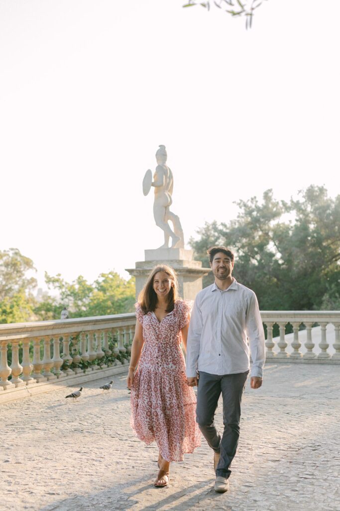 Young couple walking with happy faces after the surprise marriage proposal on the top of MNAC museum in Barcelona